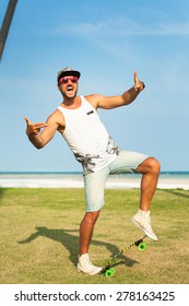 Young Handsome Hipster Man Relaxed At Sunny Day On The Park, After Training,wearing Stylish Shirt And Bright Sunglasses,skateboard.smiles And Laughs,hipster Cap,swagger Man,mans Fashion,summer Outfit
