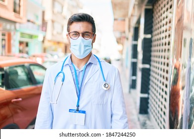 Young Handsome Hispanic Doctor Wearing Uniform And Coronavirus Protection Medical Mask Standing At Town Street.