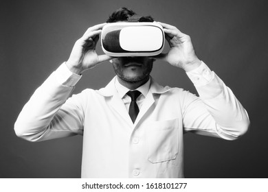 Young Handsome Hispanic Man Doctor Using Virtual Reality Headset