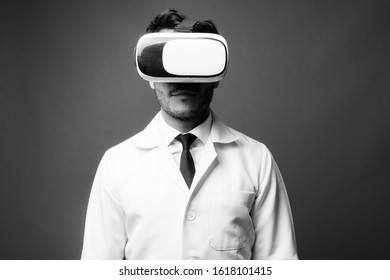 Young Handsome Hispanic Man Doctor Using Virtual Reality Headset