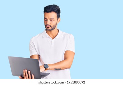 Young Handsome Hispanic Man Working Using Computer Laptop Thinking Attitude And Sober Expression Looking Self Confident 
