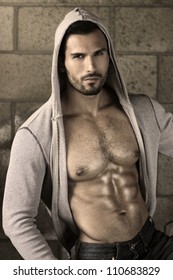 Young Handsome Macho Man With Open Jacket Revealing Muscular Chest And Abs