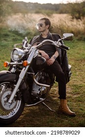 Young Handsome Male Biker Is Sitting And Smoking On Motor Bike