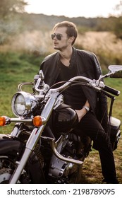 Young Handsome Male Biker Is Sitting And Smoking On Motor Bike