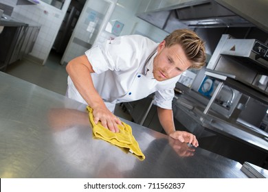 Young Handsome Male Cook Cleaning Restaurant Kitchen