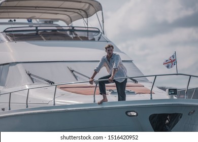 Young handsome male model is posing on the super yacht