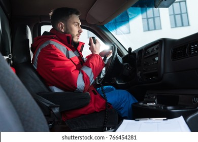 young handsome male paramedic talking by portable radio