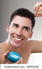 Young Handsome Man Applying Hair Gel Close Up