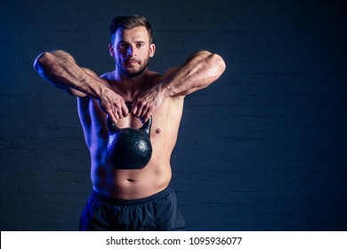 Young And Handsome Man Athlete Doing Exercise For The Muscles Of The Body With Weights (dumbbell) In The Gym