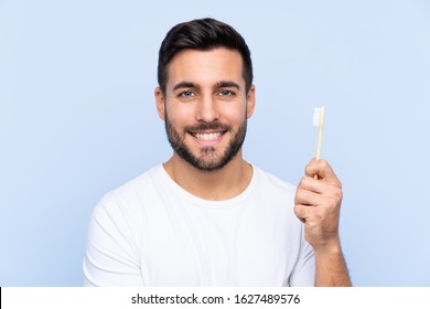 Young handsome man with beard brushing his teeth over isolated background smiling a lot - Powered by Shutterstock