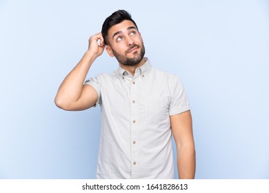Young handsome man with beard over isolated blue background having doubts and with confuse face expression - Shutterstock ID 1641828613
