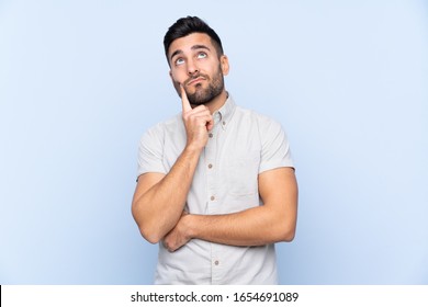 Young handsome man with beard over isolated blue background thinking an idea - Shutterstock ID 1654691089