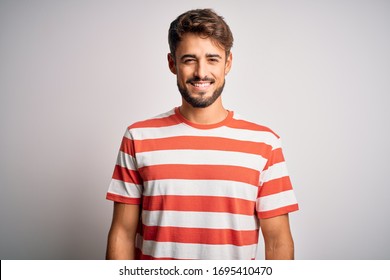 Young handsome man with beard wearing striped t-shirt standing over white background with a happy and cool smile on face. Lucky person. - Powered by Shutterstock