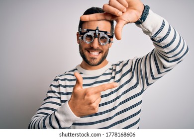 Young Handsome Man With Beard Wearing Optometry Glasses Over Isolated White Background Smiling Making Frame With Hands And Fingers With Happy Face. Creativity And Photography Concept.