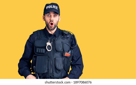 Young Handsome Man With Beard Wearing Police Uniform Afraid And Shocked With Surprise Expression, Fear And Excited Face. 