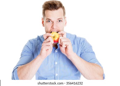 Young handsome man is biting an apple