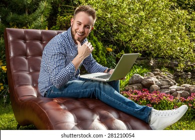 Young handsome man in casual clothes sit in luxury sofa with notebook in summer garden. - Shutterstock ID 281210054