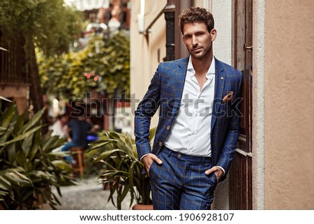 Young handsome man in classic suit with checked pattern 