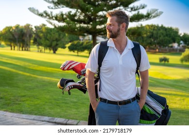 Young Handsome Man At The Course Carrying A Golf Bag.