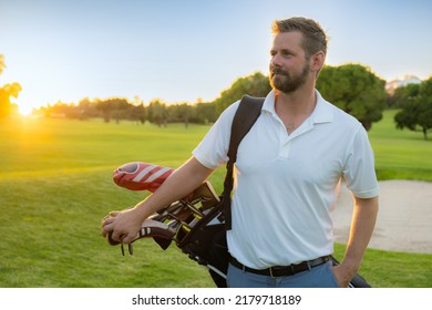 Young Handsome Man At The Course Carrying A Golf Bag.