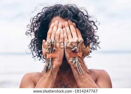 young handsome man cover his face with hands on the beach