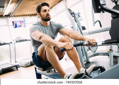 Young Handsome Man Doing Exercises In Gym