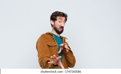 Young Handsome Man Feeling Disgusted And Nauseous, Backing Away From Something Nasty, Smelly Or Stinky, Saying Yuck Against Flat Wall