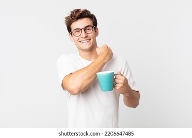 Young Handsome Man Feeling Happy And Facing A Challenge Or Celebrating And Holding A Coffee Cup