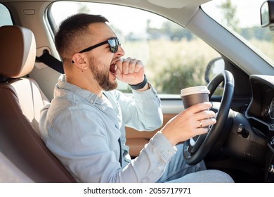 Young handsome man feeling tired and yawning while driving a car.