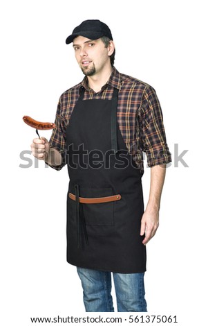 Young handsome man grilling, cooking meat sausage isolated