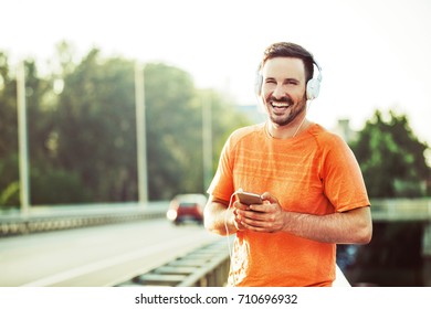 Young handsome man is having break after exercise on the bridge.