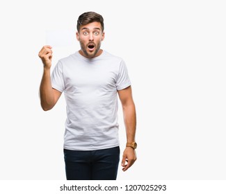 Young Handsome Man Holding Blank Card Over Isolated Background Scared In Shock With A Surprise Face, Afraid And Excited With Fear Expression