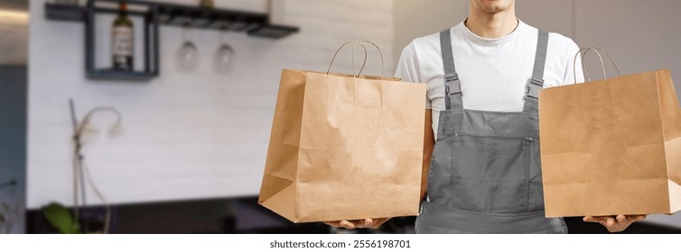 Young handsome man holding delivery paper bag - Powered by Shutterstock