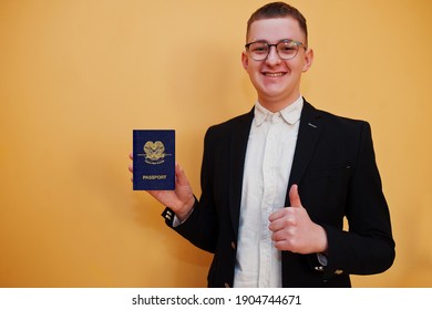 Young handsome man holding Independent State of Papua New Guinea passport id over yellow background, happy and show thumb up.  Travel to Oceania country concept.