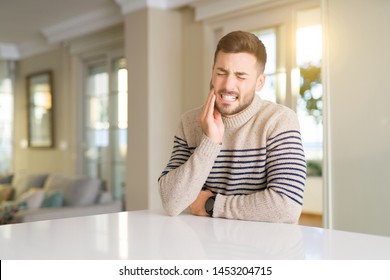 Young Handsome Man At Home Touching Mouth With Hand With Painful Expression Because Of Toothache Or Dental Illness On Teeth. Dentist Concept.