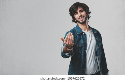 Young Handsome Man Inviting To Come, Confident And Smiling Making A Gesture With Hand, Being Positive And Friendly