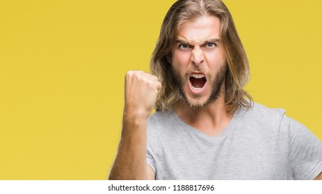 Young Handsome Man With Long Hair Over Isolated Background Holding Football Ball Annoyed And Frustrated Shouting With Anger, Crazy And Yelling With Raised Hand, Anger Concept