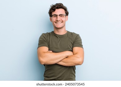 young handsome man looking like a happy, proud and satisfied achiever smiling with arms crossed - Powered by Shutterstock