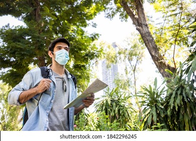 Young handsome man looking paper map and using sun glasses in public park with a happy face standing and smiling. Concept of travel and environment studies. Soft focus and blur - Powered by Shutterstock