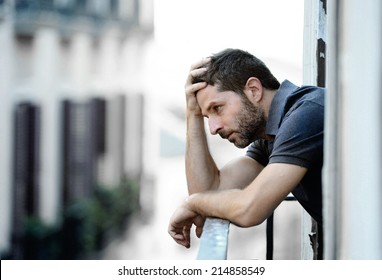 Young Handsome Man Outside At House Balcony Alone Looking Depressed, Destroyed, Sad And Suffering Emotional Crisis And Grief In Life Problem Concept On An Urban Background 