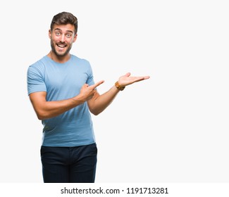 Young handsome man over isolated background amazed and smiling to the camera while presenting with hand and pointing with finger. - Shutterstock ID 1191713281