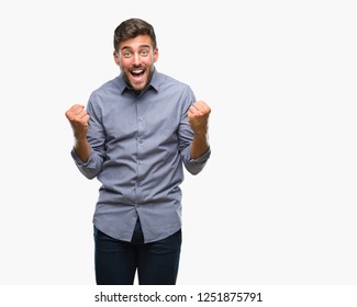 Young handsome man over isolated background celebrating surprised and amazed for success with arms raised and open eyes. Winner concept. - Shutterstock ID 1251875791