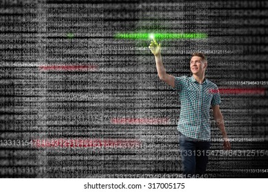Young handsome man pointing at binary digital touchscreen