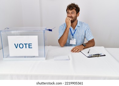 Young Handsome Man At Political Election Sitting By Ballot Looking Stressed And Nervous With Hands On Mouth Biting Nails. Anxiety Problem. 
