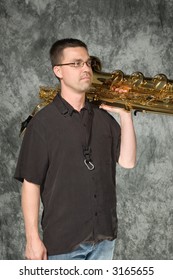 Young Handsome Man Posing In Front Of Portrait Backdrop With Saxaphone