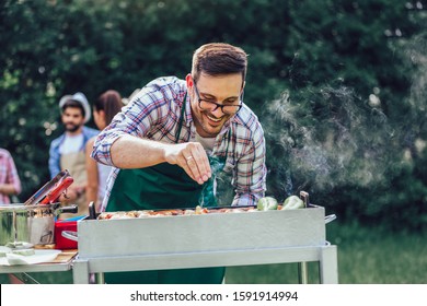 Young handsome man preparing barbecue for friends.
