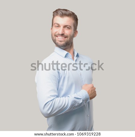 young handsome man proud expression wearing blue t shirt. . person isolated against monochrome background