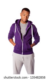 Young Handsome Man Ready For Sports Wearing Purple Hooded Sweatshirt And Gray Training Pants, Isolated.