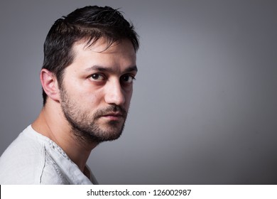 Young Handsome Man With Serious Expression On Dark Background