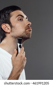 Young handsome man shaving over grey background. - Shutterstock ID 461991205